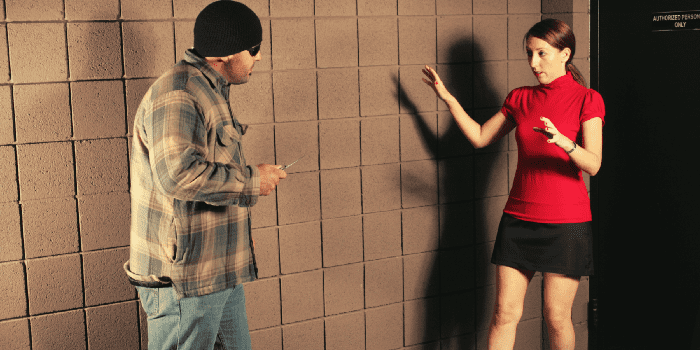 Woman in red shirt in defensive stance against a bad guy